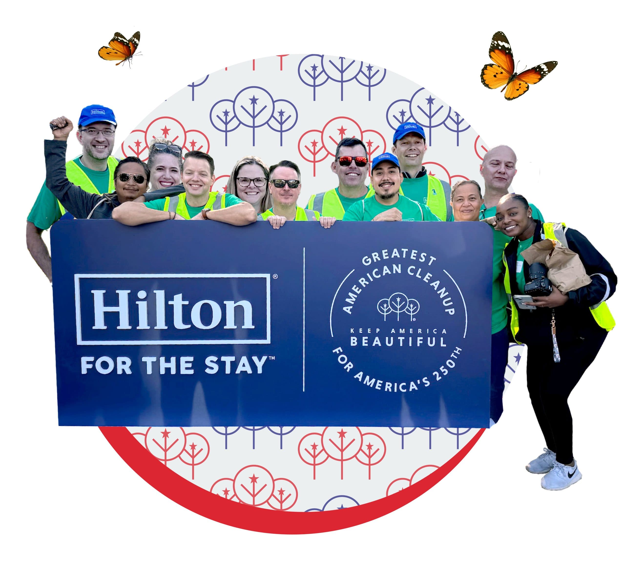 Cut-out group photo of about a dozen people in green t-shirts and yellow hi-vis vests, several in blue Hilton caps, crowded behind a large navy board reading Hilton FOR THE STAY next to a round GREATEST AMERICAN CLEANUP KEEP AMERICA BEAUTIFUL FOR AMERICA'S 250TH seal. Two orange butterflies and a circle of patterned line-drawn trees frame them.