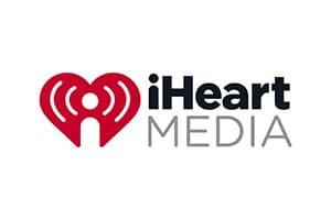iHeartMedia logo with a large red heart of broadcast waves beside iHeart in black stacked over MEDIA in grey
