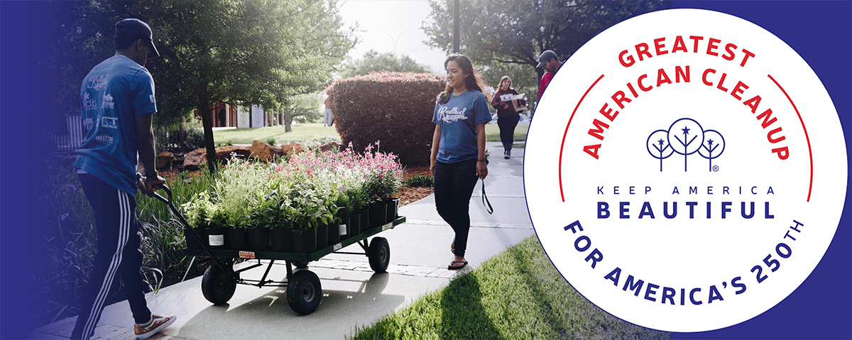 Banner artwork on a deep blue field: a young man in a blue t-shirt pulls a garden cart loaded with potted flowering plants along a path as a young woman walks alongside, beside a circular GREATEST AMERICAN CLEANUP badge.